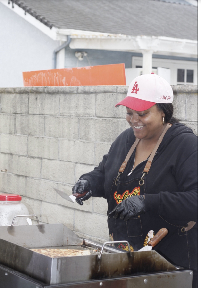 Chef Jai of Corn Lady LA smiling while cooking quesadillas on the flat top grill
